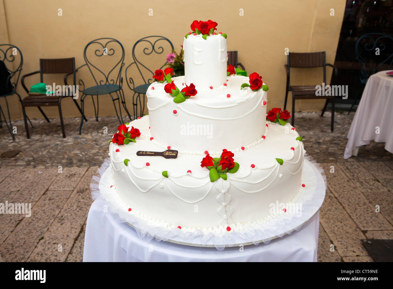 Rote Blumendekorationen auf große Hochzeitstorte Stockfoto