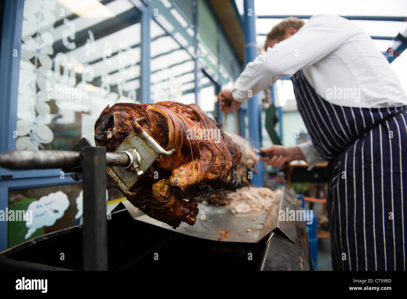 Ein Koch schnitzen einen Spieß braten Schwein braten, UK Stockfoto