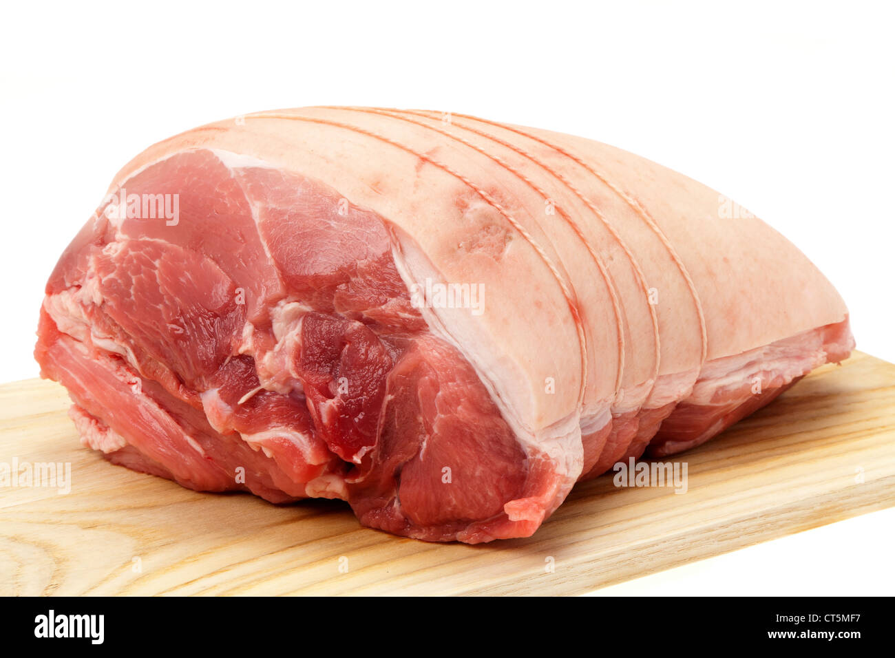 Eine ungekochte Schulter vom Schwein auf ein Holzbrett gelegt, der Metzger hat es mit Schnur gebunden und es ist jetzt Backofen bereit Stockfoto