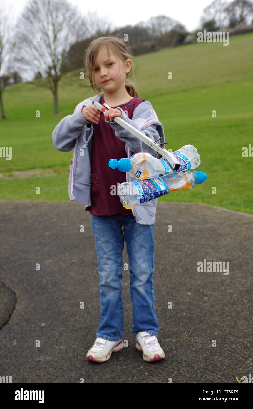 Mädchen Abholung Wurf mit einem Wurf grabbing Tool auf dem Spielplatz ihren lokalen Park. Stockfoto