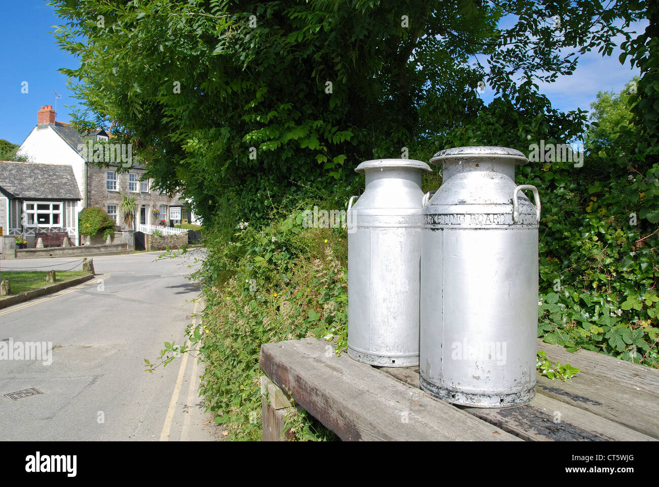 Milchkannen am Straßenrand in der Ortschaft Crantock, Cornwall, UK Stockfoto