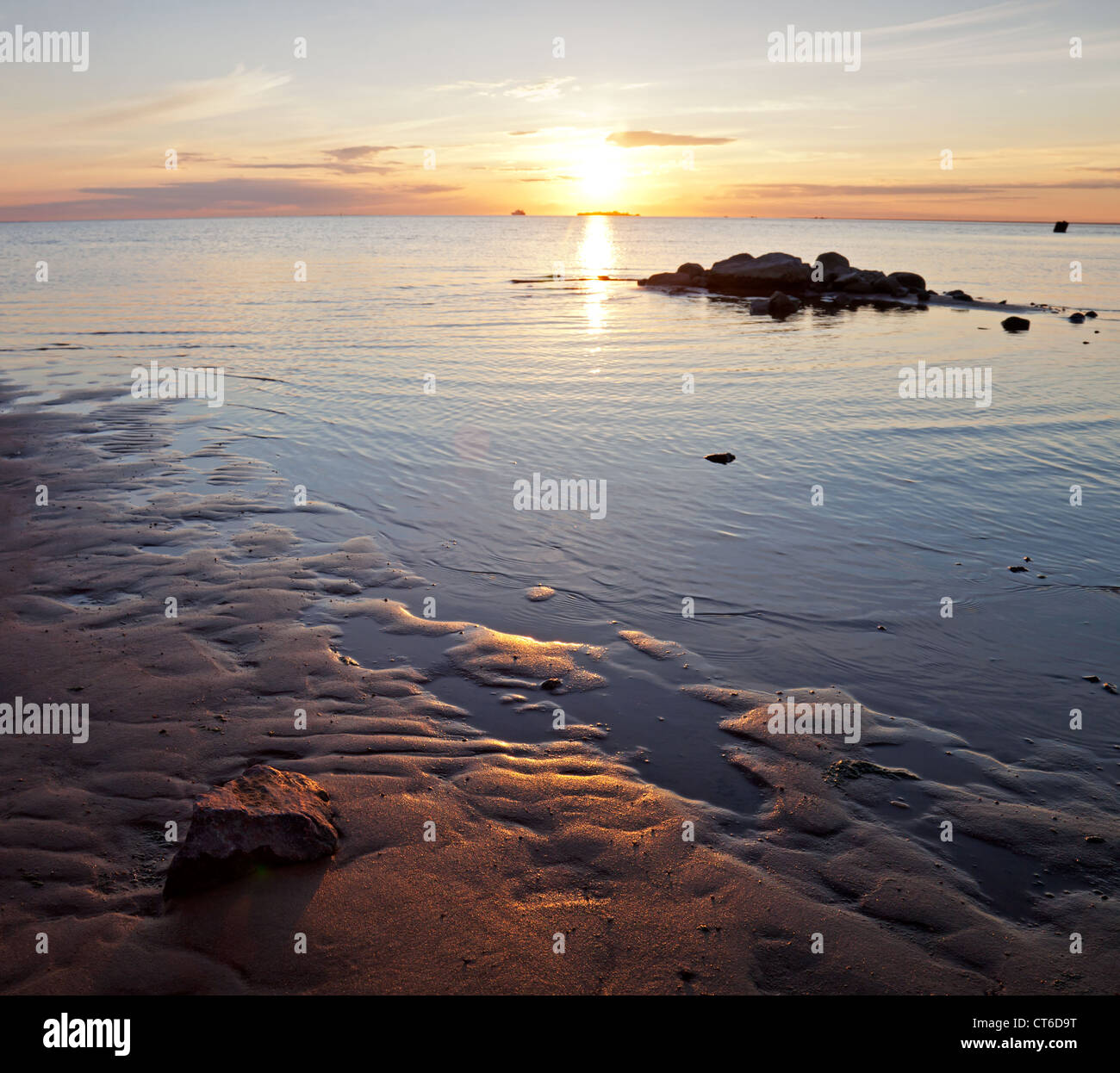 Goldener Sonnenuntergang an der Ostsee. Küstenlandschaft mit der Einstellung der Sonne Reflexionen auf dem Wasser und sand Stockfoto