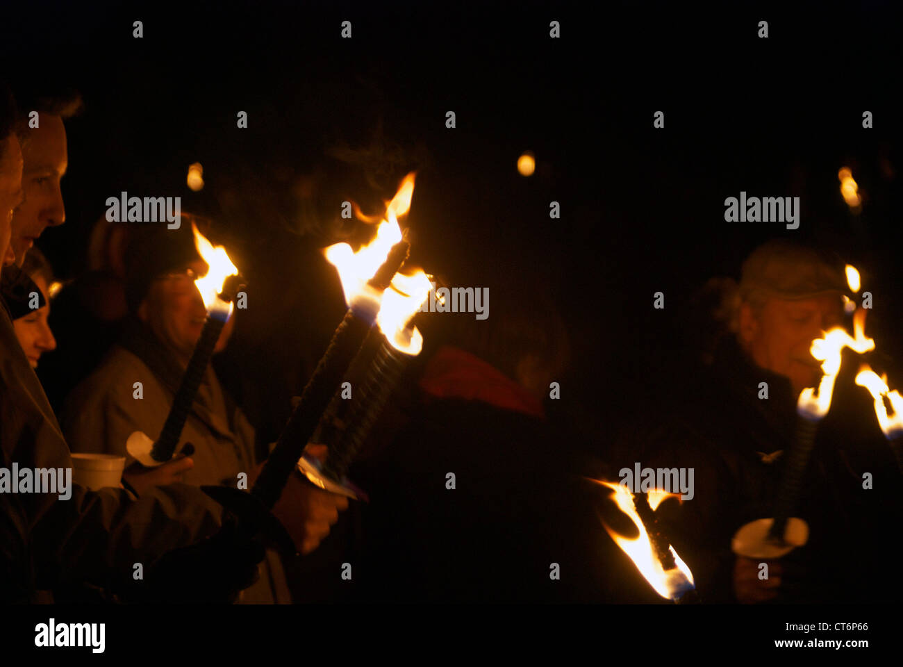 Menschen halten beleuchtete Flammen Stockfoto