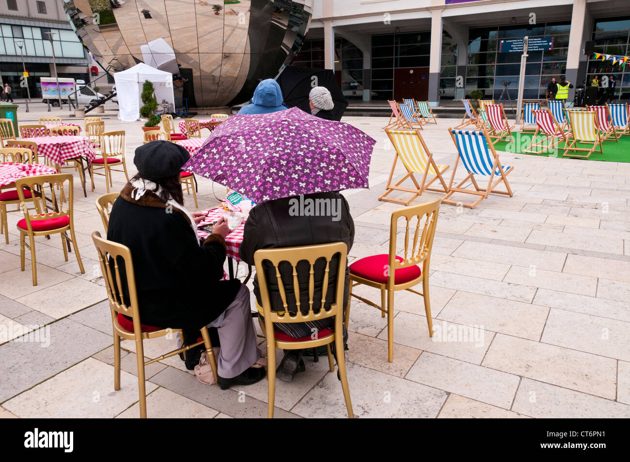 Menschen amüsieren sich trotz schlechten Wetters im Millennium Square in Stadtzentrum von Bristol, UK Stockfoto