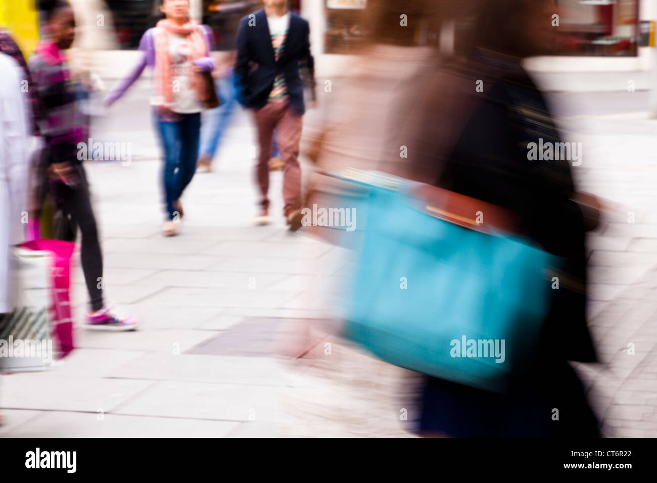 Bewegungsunschärfe von Menschen zu Fuß und shopping in einer britischen Stadt Stockfoto