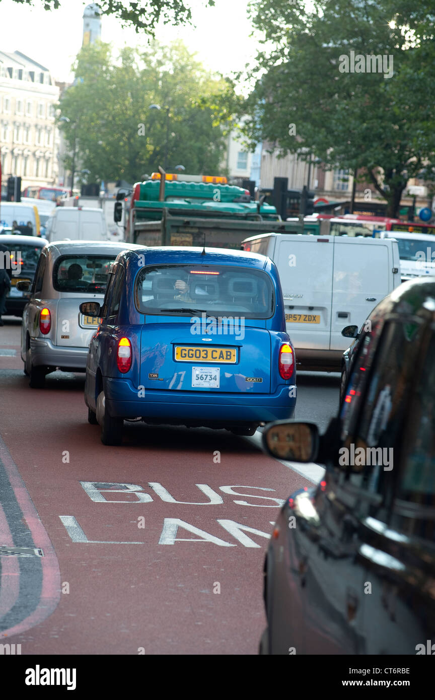 Taxis mit einer Busspur auf einer verkehrsreichen Straße in London, England. Stockfoto