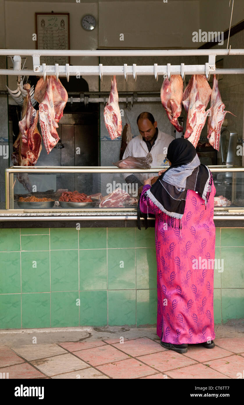 Eine arabische Frau shopping für Fleisch von einem Metzger, der Souk, Medina, Taroudant, Marokko Afrika Stockfoto