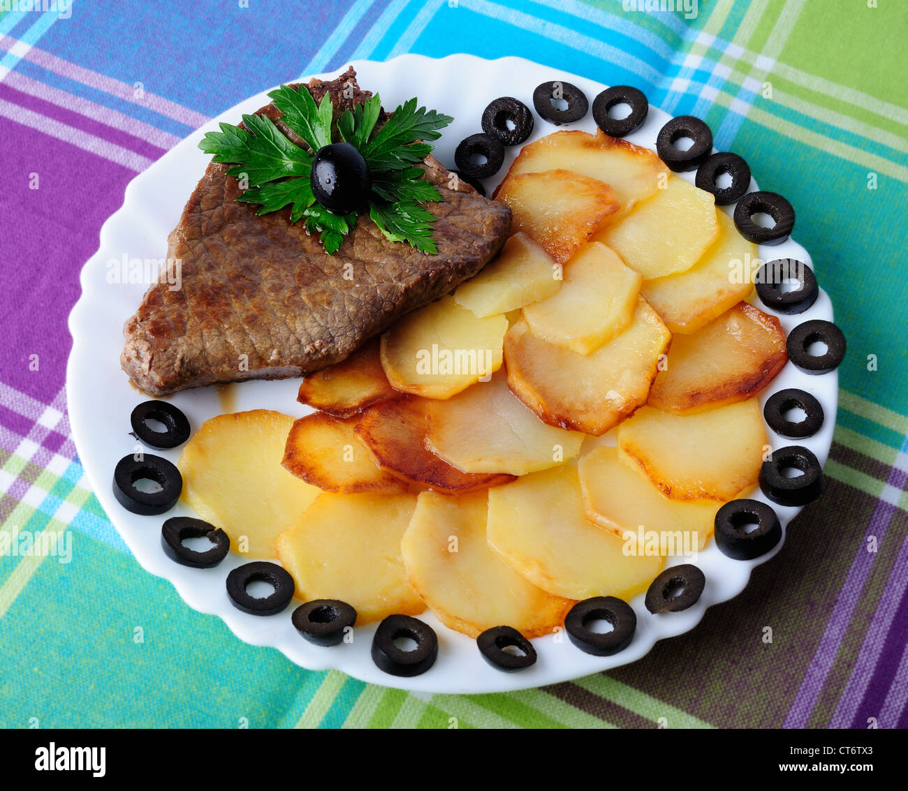 Kalbfleisch mit gebratenen Kartoffeln auf einem Teller Stockfoto