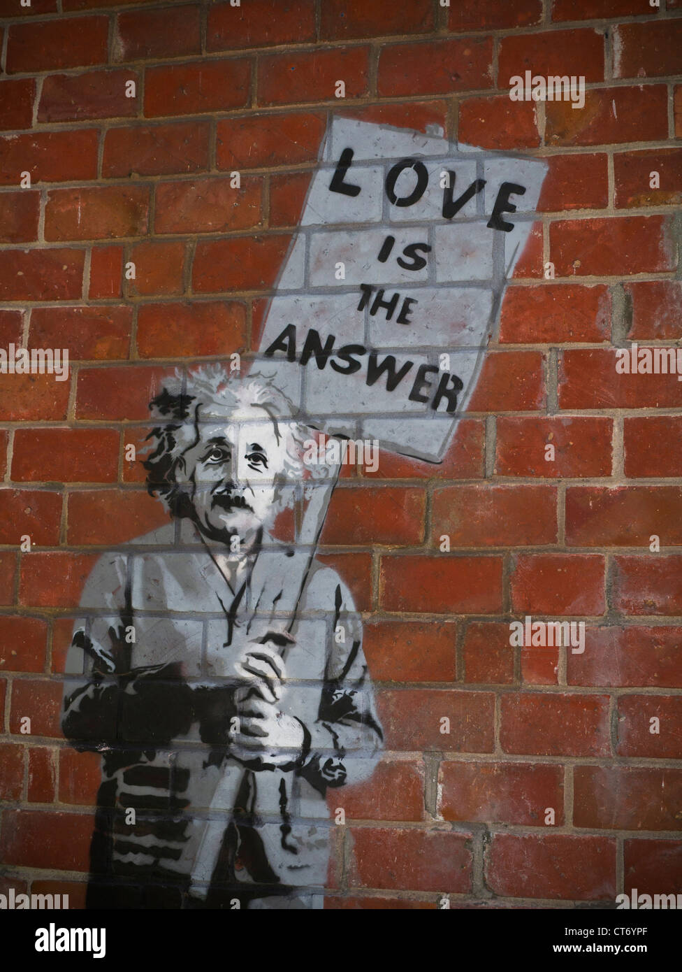 „BANKSY“ EINSTEIN „Love is the answer“ authentische Banksy-Kunst „Graffiti“ auf der Ziegelwand Albert Einstein mit dem Plakat „Carmel“ von Sea California USA Stockfoto