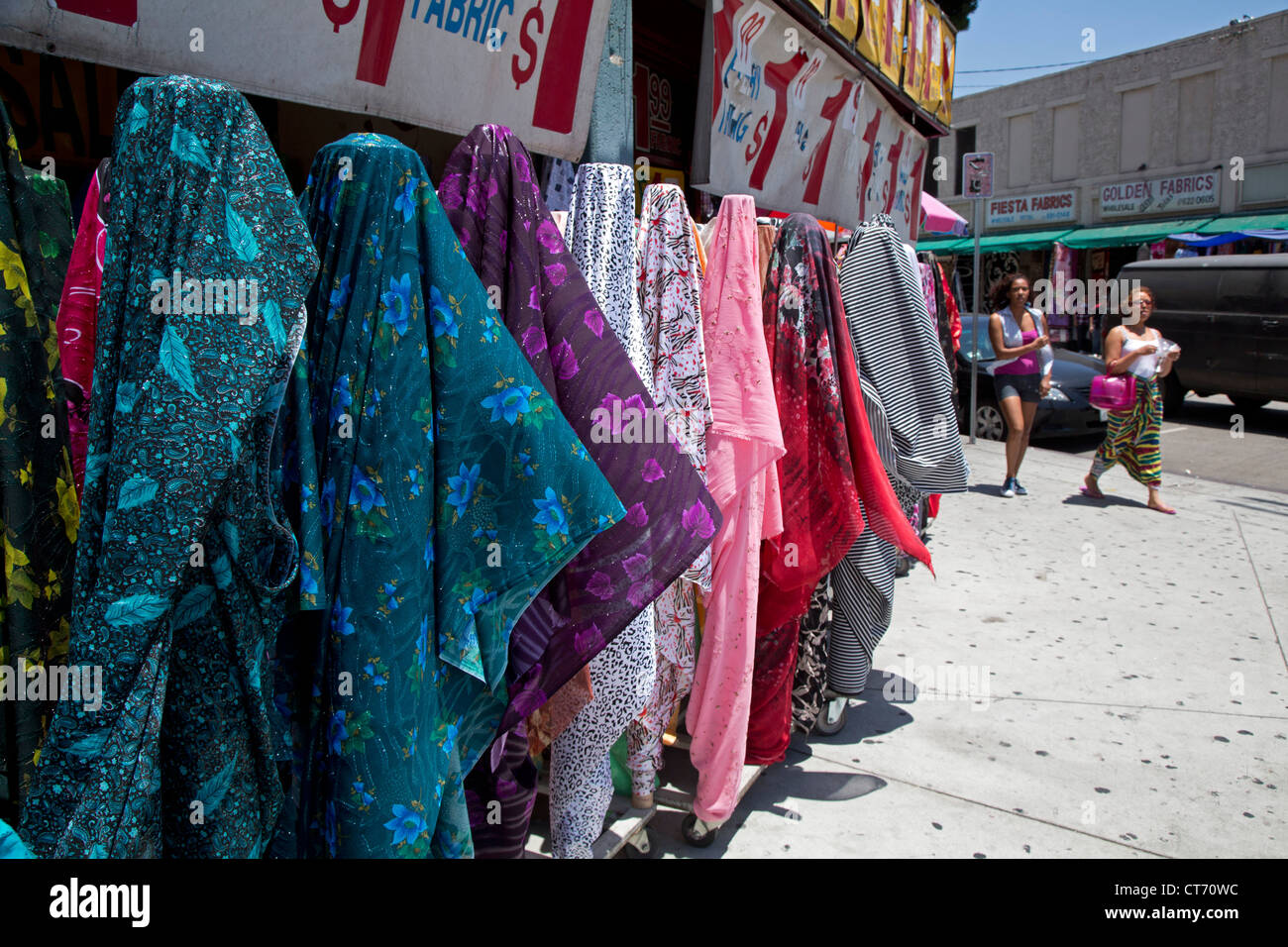 Los Angeles, Kalifornien - Kleidung und Stoff für den Verkauf auf dem Bürgersteig vor Geschäften in den Fashion District. Stockfoto