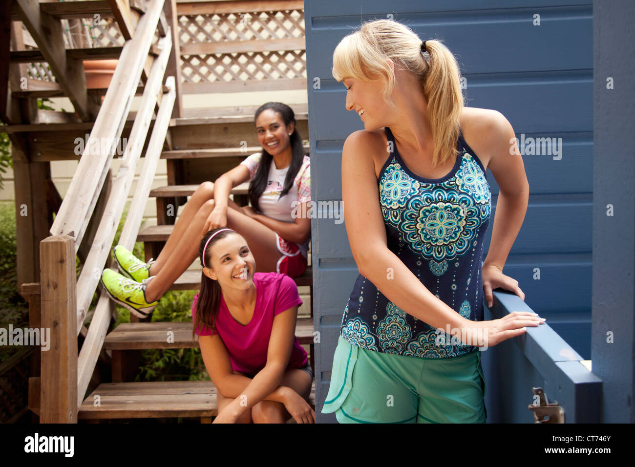 Drei Mädchen auf einem Deck in Fitnesskleidung. Stockfoto