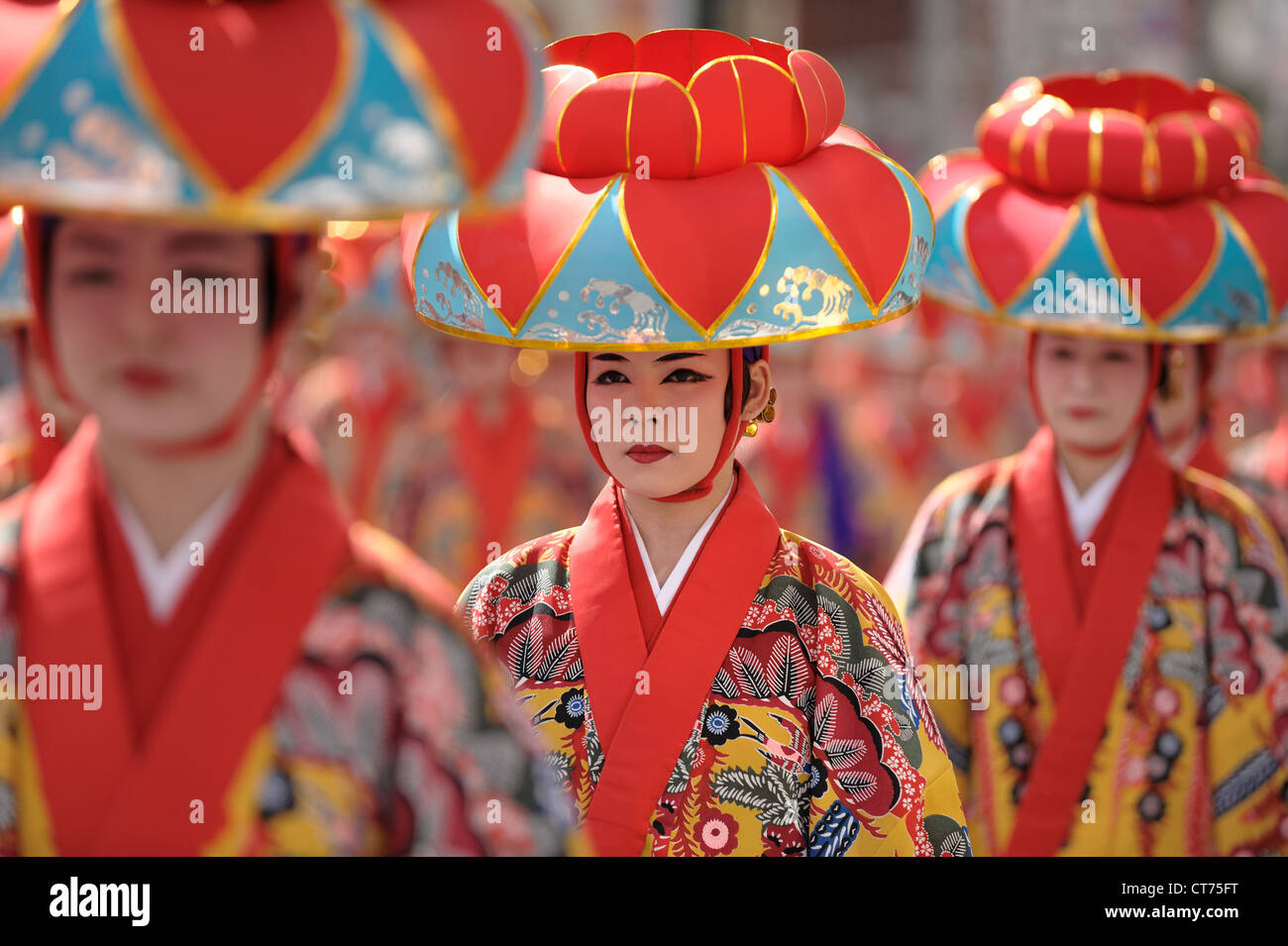 Traditionelle Tanzkünstler begeben sich während eines lokalen Festivals in Okinawa, Japan, zum nächsten Ort. Stockfoto