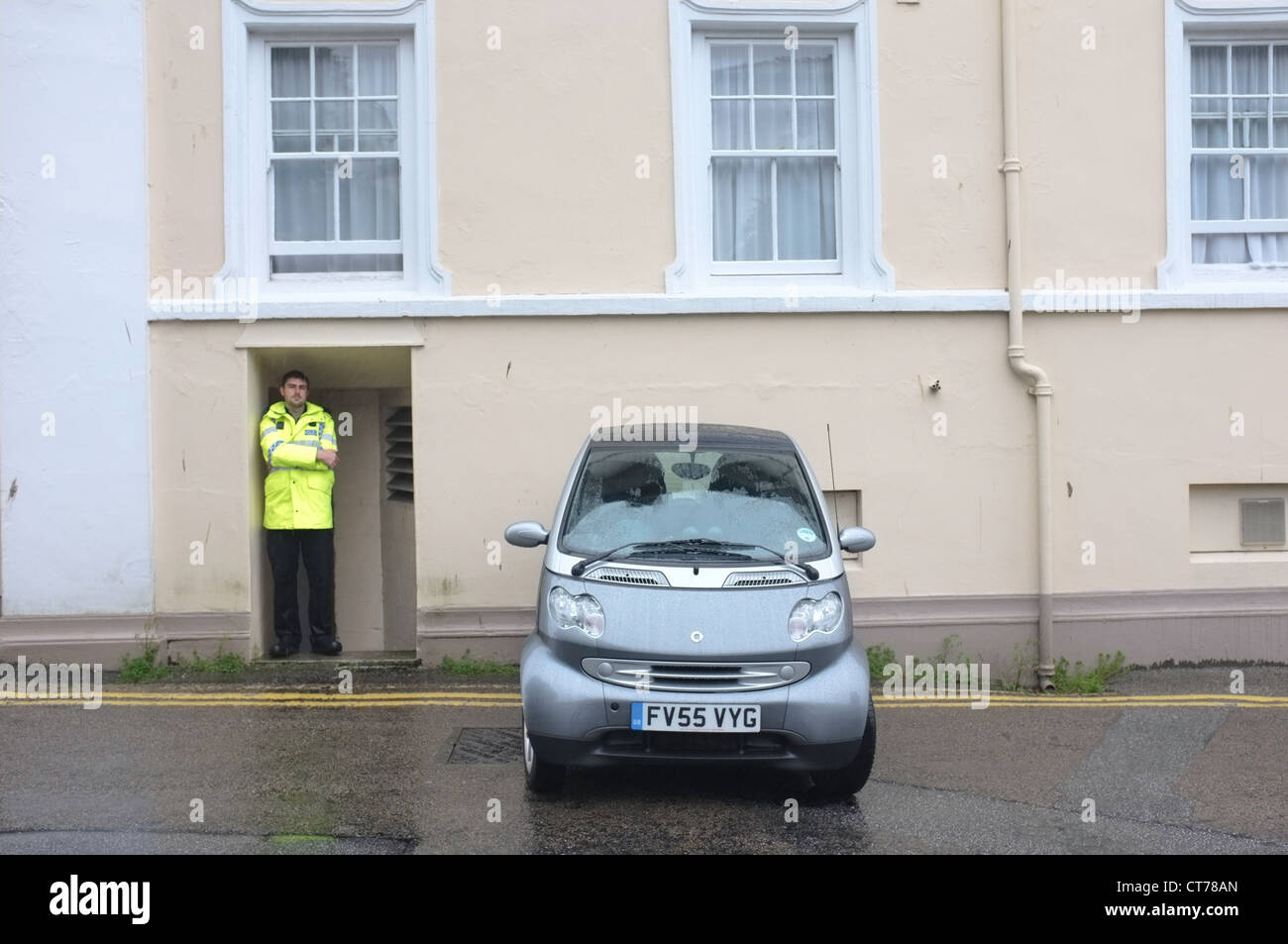 Ein schlecht geparktes Auto bewacht von einem Polizisten in Falmouth, Cornwall Stockfoto