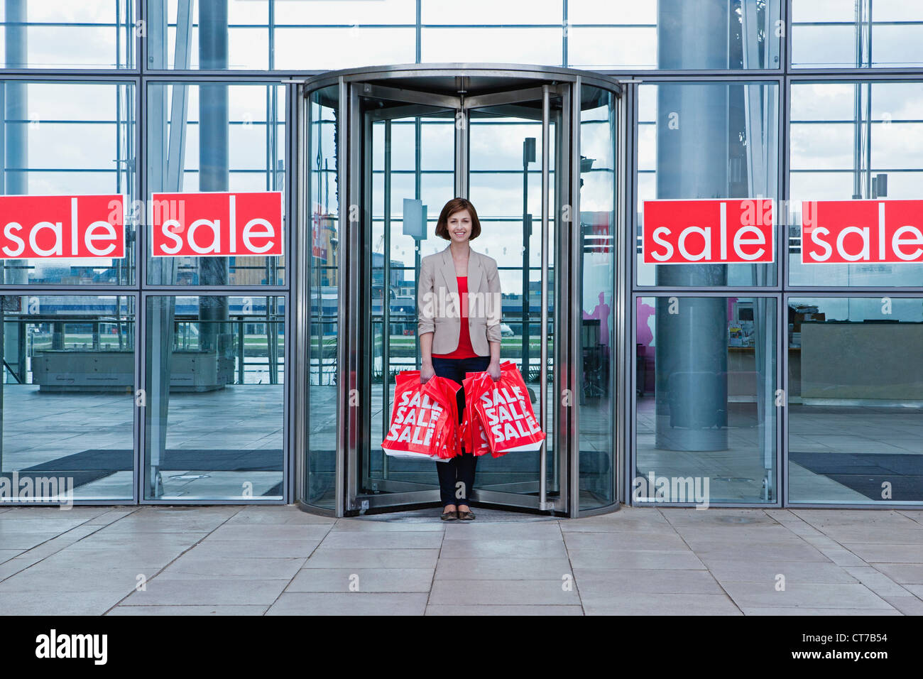 Frau in Shop Tür mit Verkauf Taschen Stockfoto
