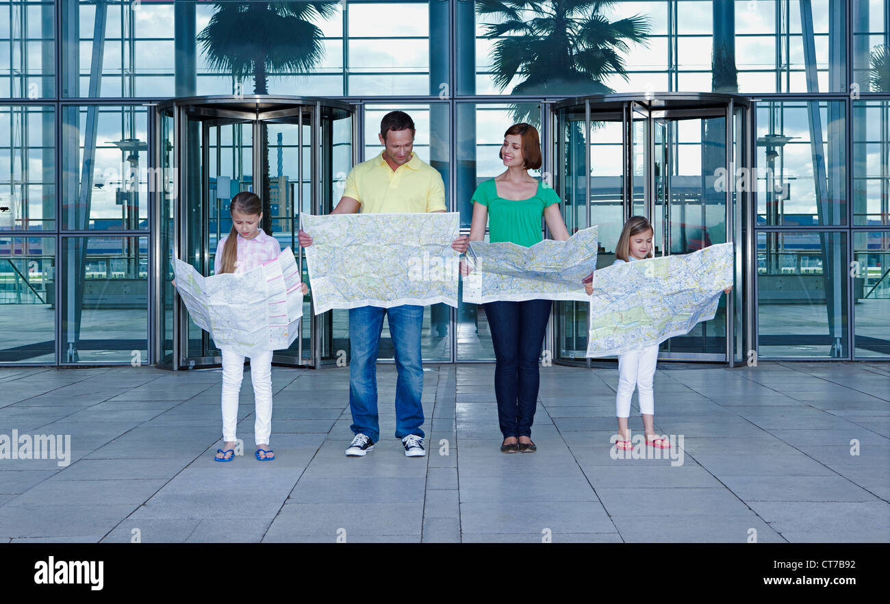 Familie mit Karten außerhalb Flughafen Stockfoto
