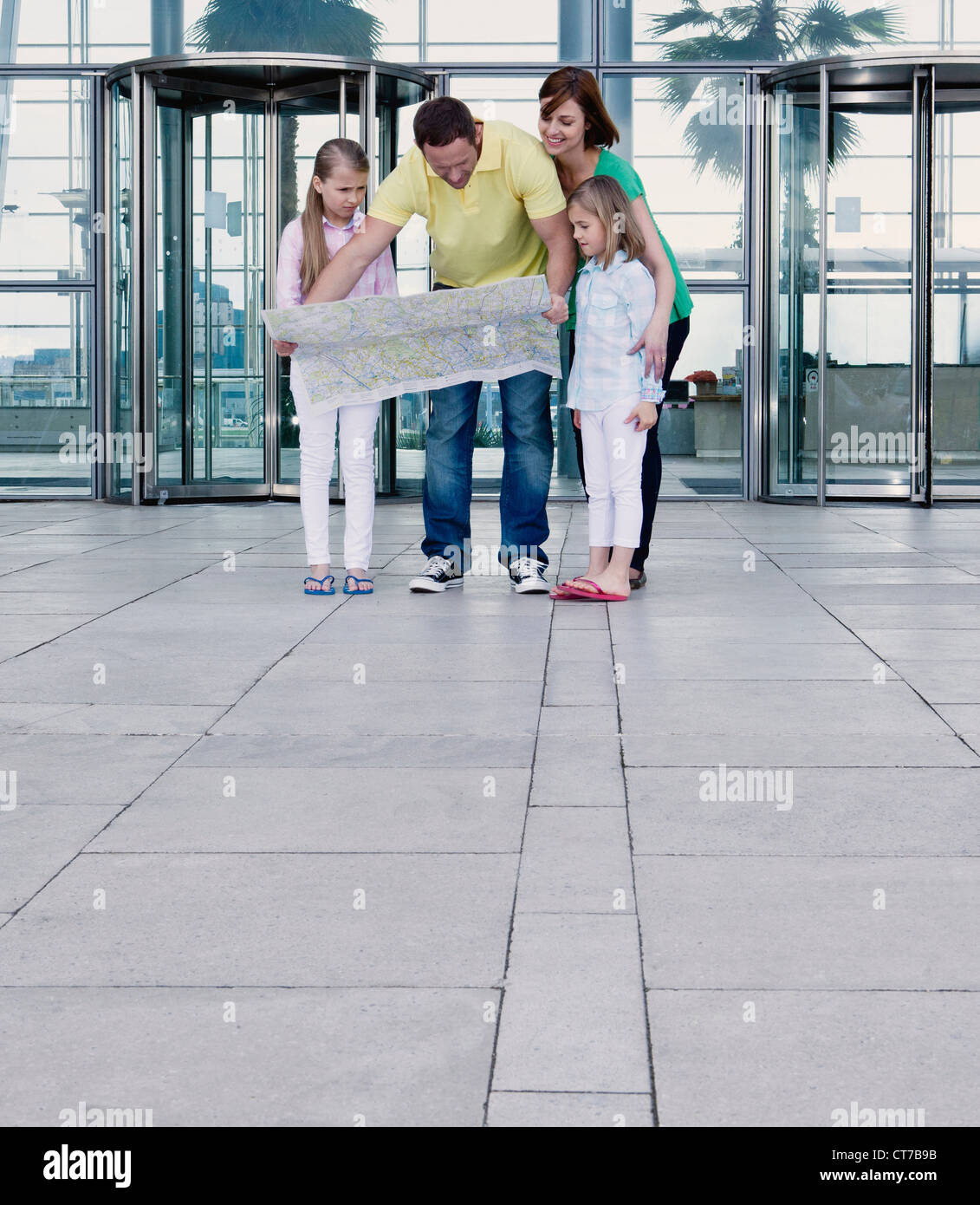 Familie mit Karte außerhalb Flughafen Stockfoto