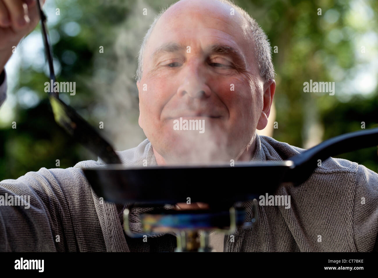 Senior woman Kochen camping-Kocher Stockfoto