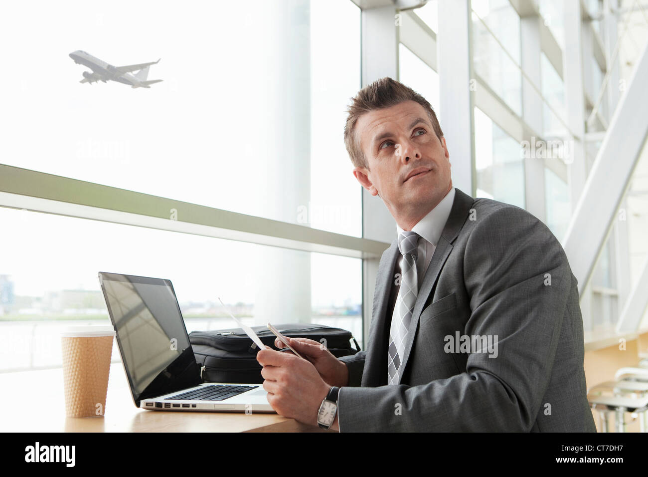 Geschäftsmann mit Laptop in Flughafen Stockfoto