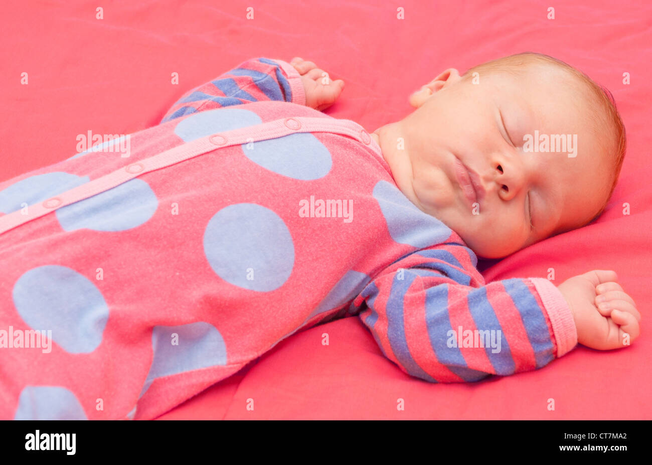 Neugeborene schlafen auf rosa Decke Stockfoto