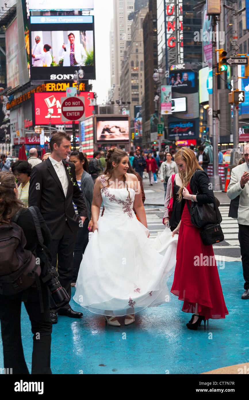 Junges Paar zu heiraten und mit Hochzeit Fotos, die auf dem Times Square in Manhattan, New York City Stockfoto