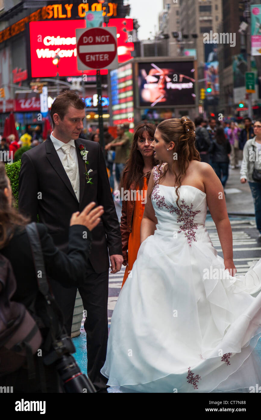Junges Paar zu heiraten und mit Hochzeit Fotos, die auf dem Times Square in Manhattan, New York City Stockfoto