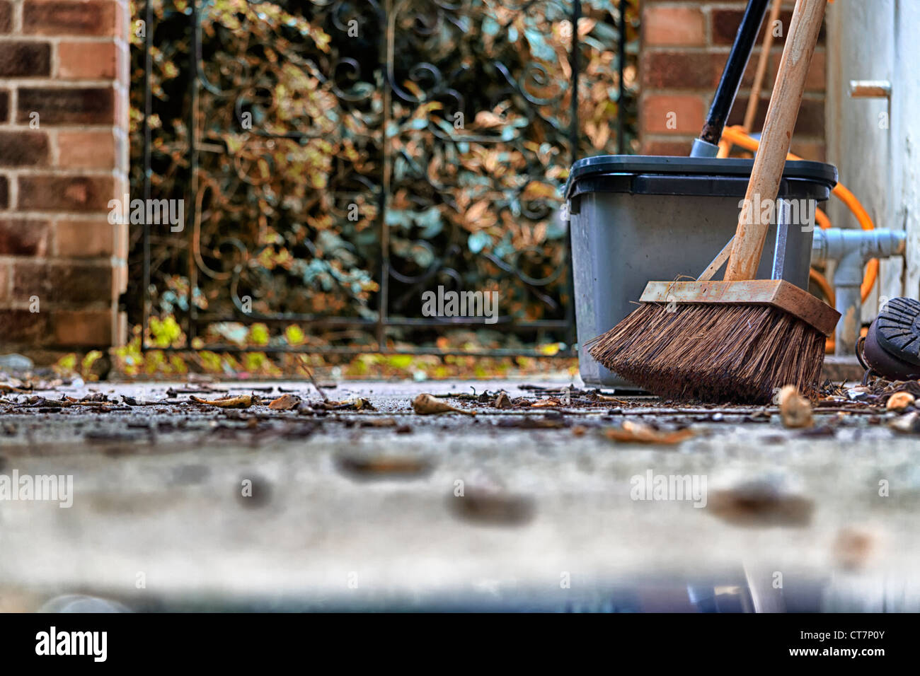 Herbstlaub auf dem Weg mit Hof Besen und Eimer Stockfoto