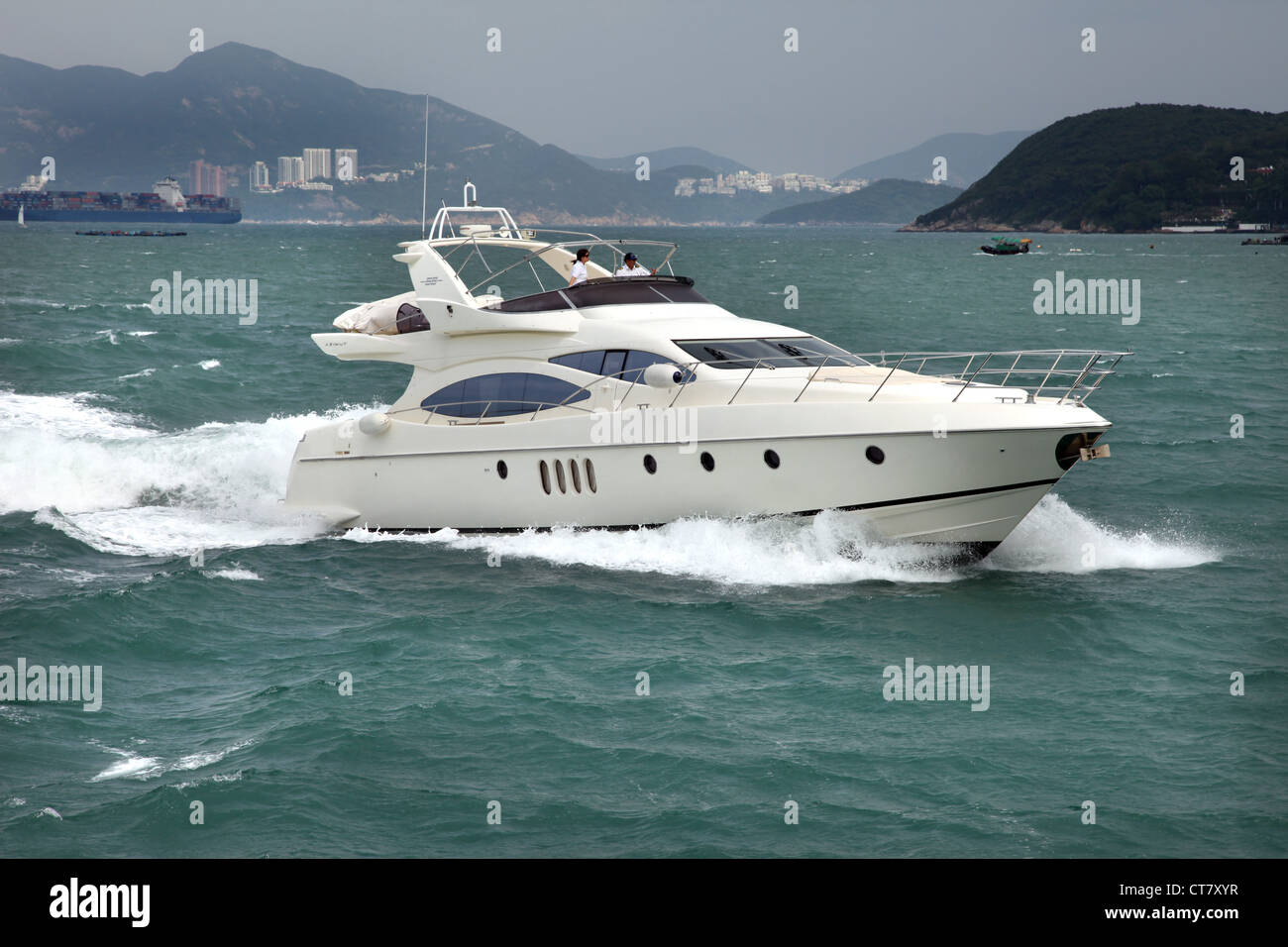 Es ist ein Foto von einem Boot in Hong Kong im Victoria Harbour. Wir sehen die Stadt in He Hintergrund. Speed Boot der reiche Geschäftsmann Stockfoto