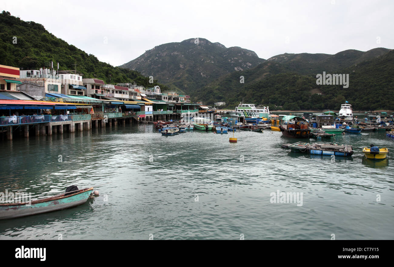 Es ist ein Foto von Fischfarmen Dorf auf Frachtschiffen in Hong Kong. Wir können sehen, dass er in der Bucht auf Kunststoff-Fässer schwebt. Stockfoto