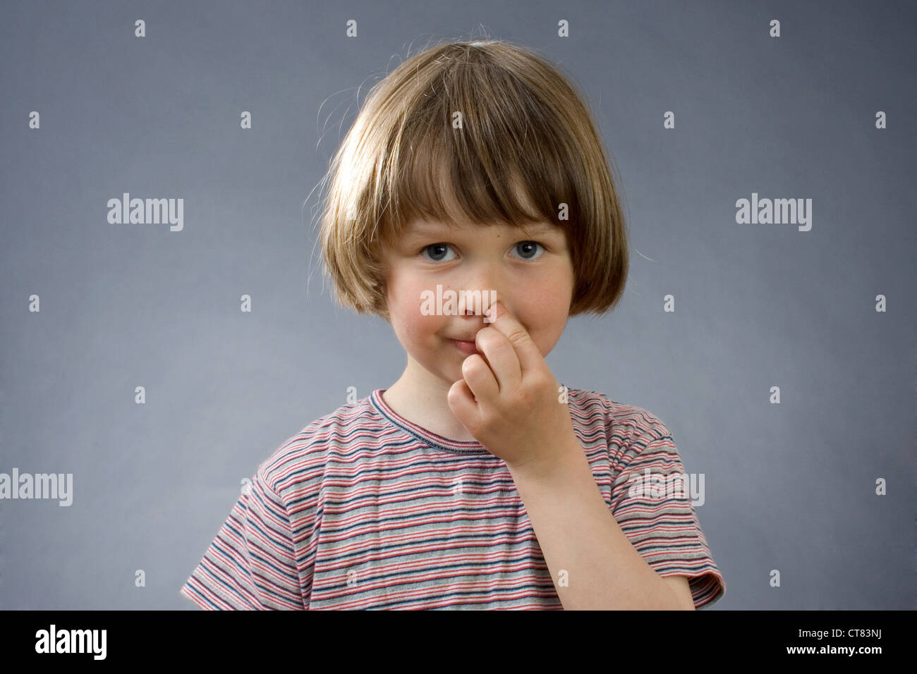 Ein Kind mit seinem Finger in der Nase Stockfoto