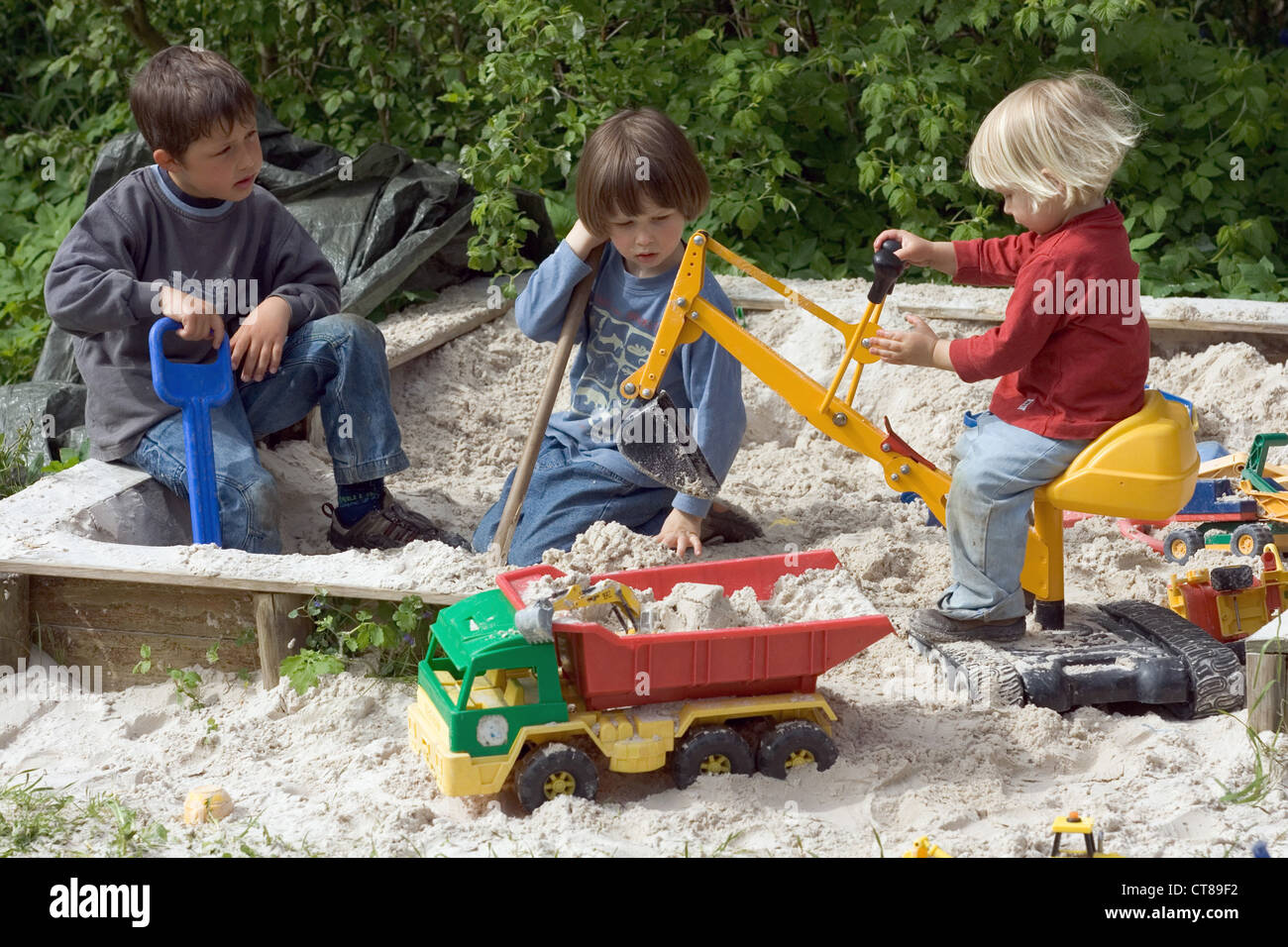Drei Kinder spielen im Sandkasten Stockfoto