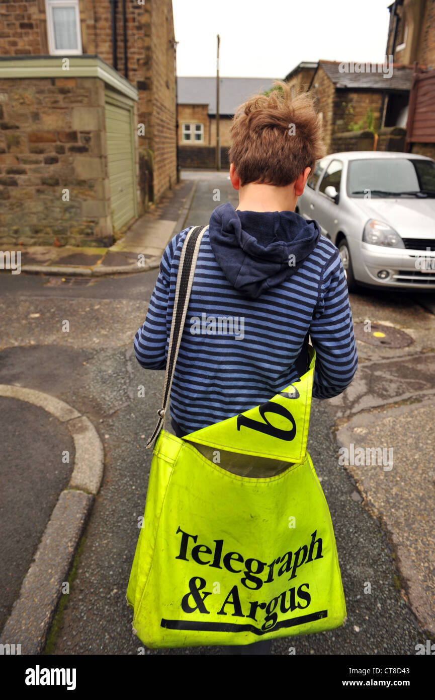 Ein Zeitungsjunge liefert Zeitungen zu Häusern, erster job, North Yorkshire. Stockfoto