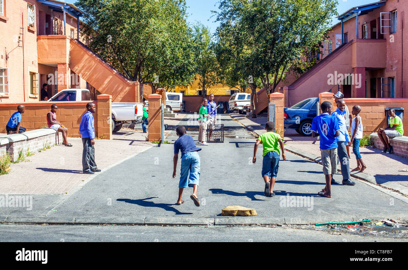 Kinder spielen Cricket auf der Straße in Langa afrikanischen Township