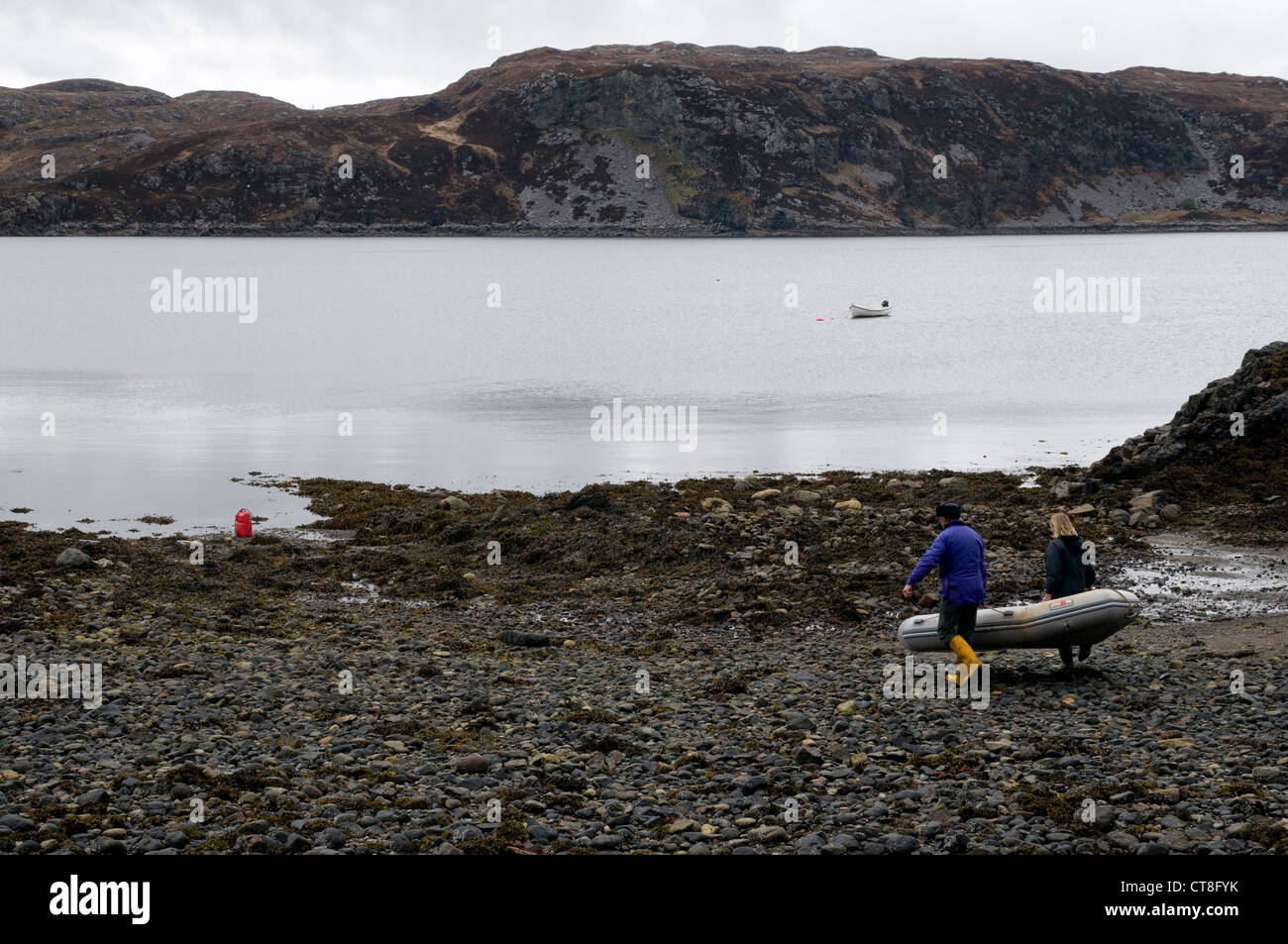 Zwei Menschen, die ein Kautschuk schmuddeligen auf der Seite ein Loch in Schottland Stockfoto