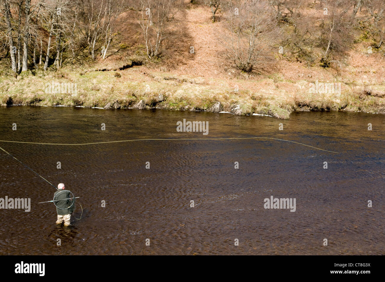 Mann Lachsfischen am Ufer eines Flusses in Schottland Stockfoto