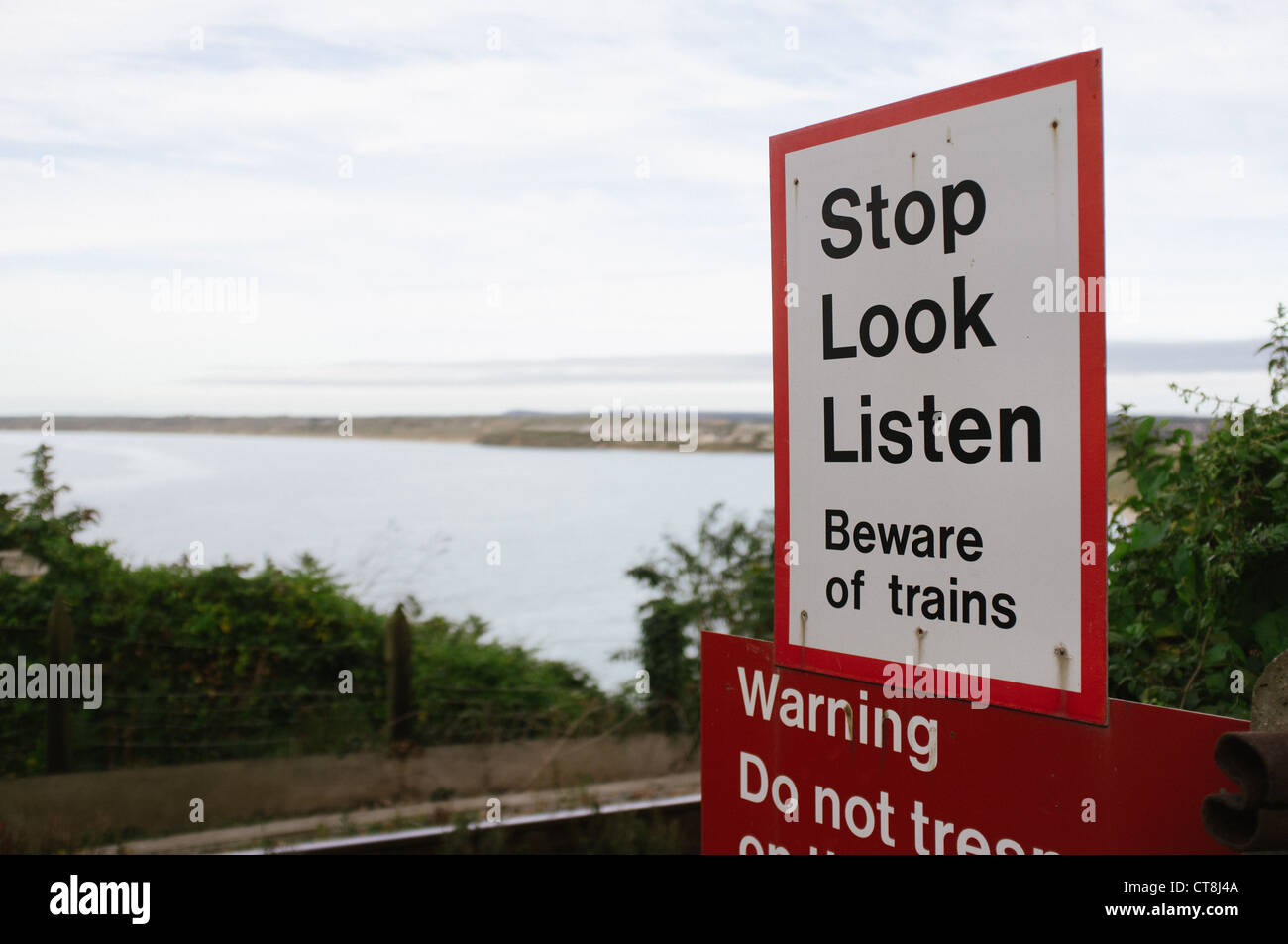 Stoppen Sie, schauen Sie, hören Sie Zeichen an einem Kreuzungspunkt auf der Bahnstrecke in Carbis Bay auf St. Ives, St Erth Nebenlinie, Cornwall Stockfoto