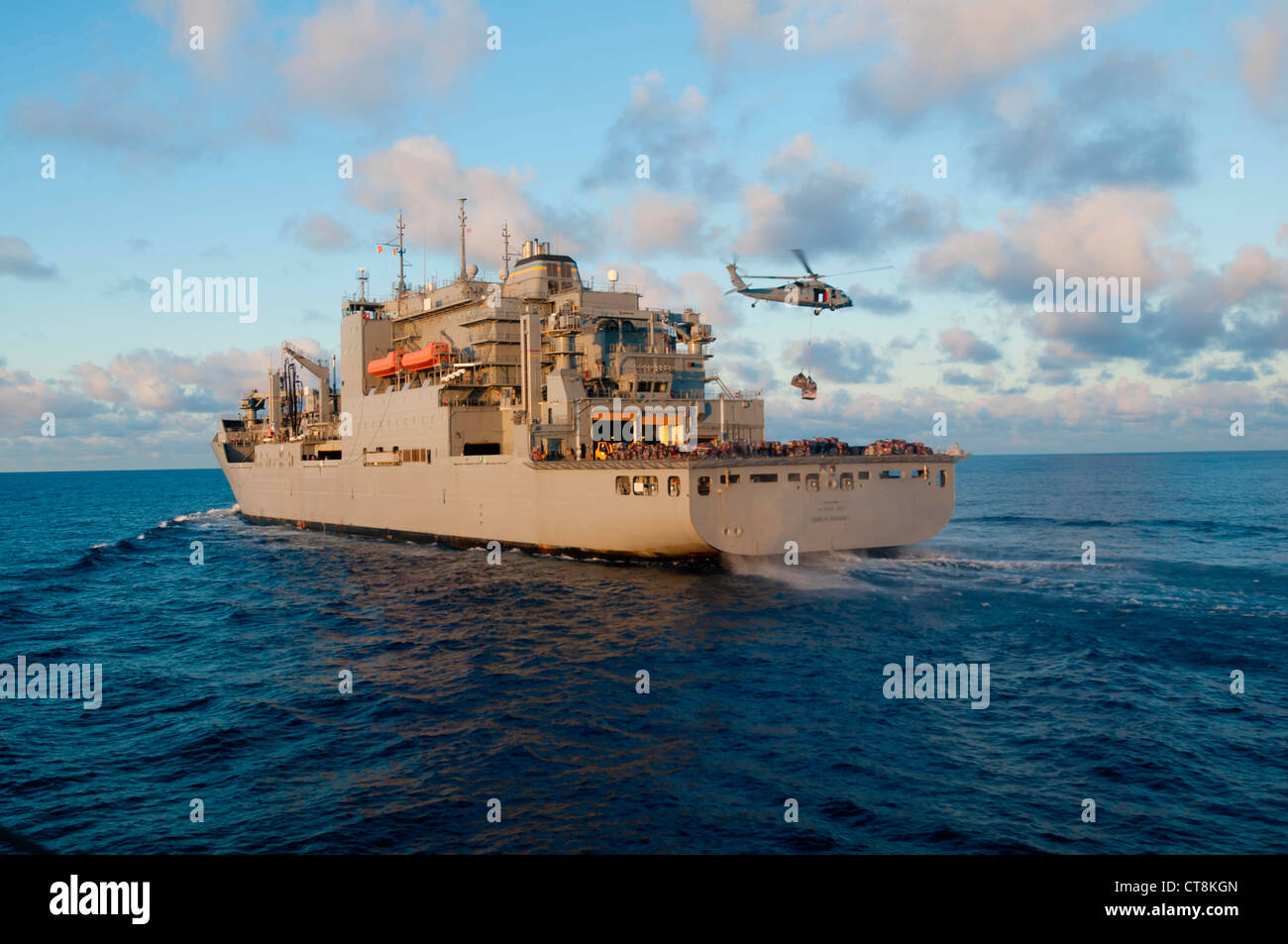 Ein US Navy SH-60 Seahawk Hubschrauber nimmt Paletten von Lieferungen von der Trockenladung und Munition Schiff USNS Amelia Earheart (T-AKE 6) während einer Nachschub auf See mit dem geführten Raketenzerstörer USS McCampbell (DDG 85), nicht abgebildet, im East China Sea 8. Juli 2012. McCampbell war im Gange, um maritime Sicherheitsoperationen und Theater-Sicherheitskooperationen in der 7. US-Flotte durchzuführen. Stockfoto