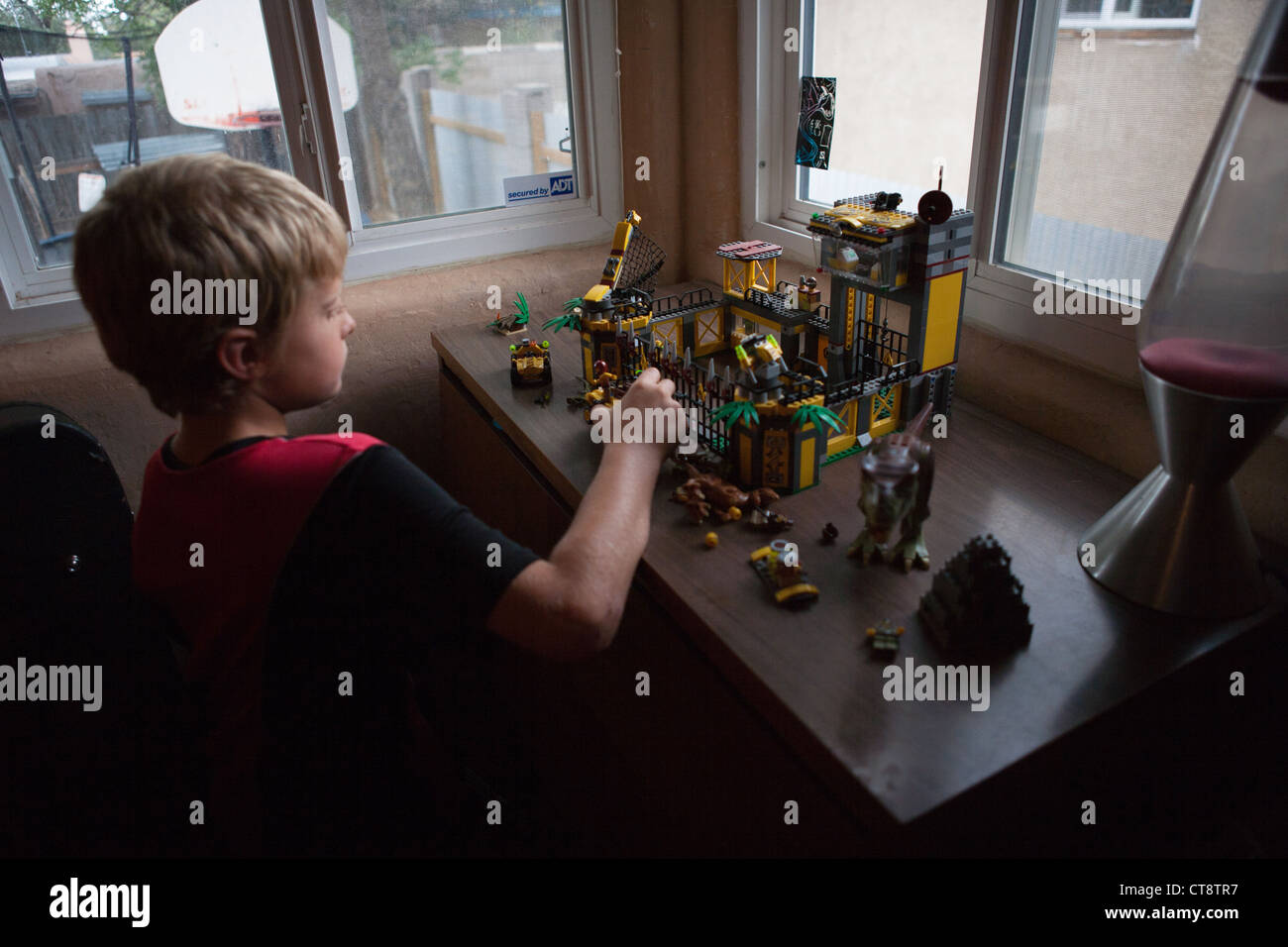 Zehn Jahre alter Junge Blick auf eine Lego-Miniatur-Szene zu Hause. Stockfoto