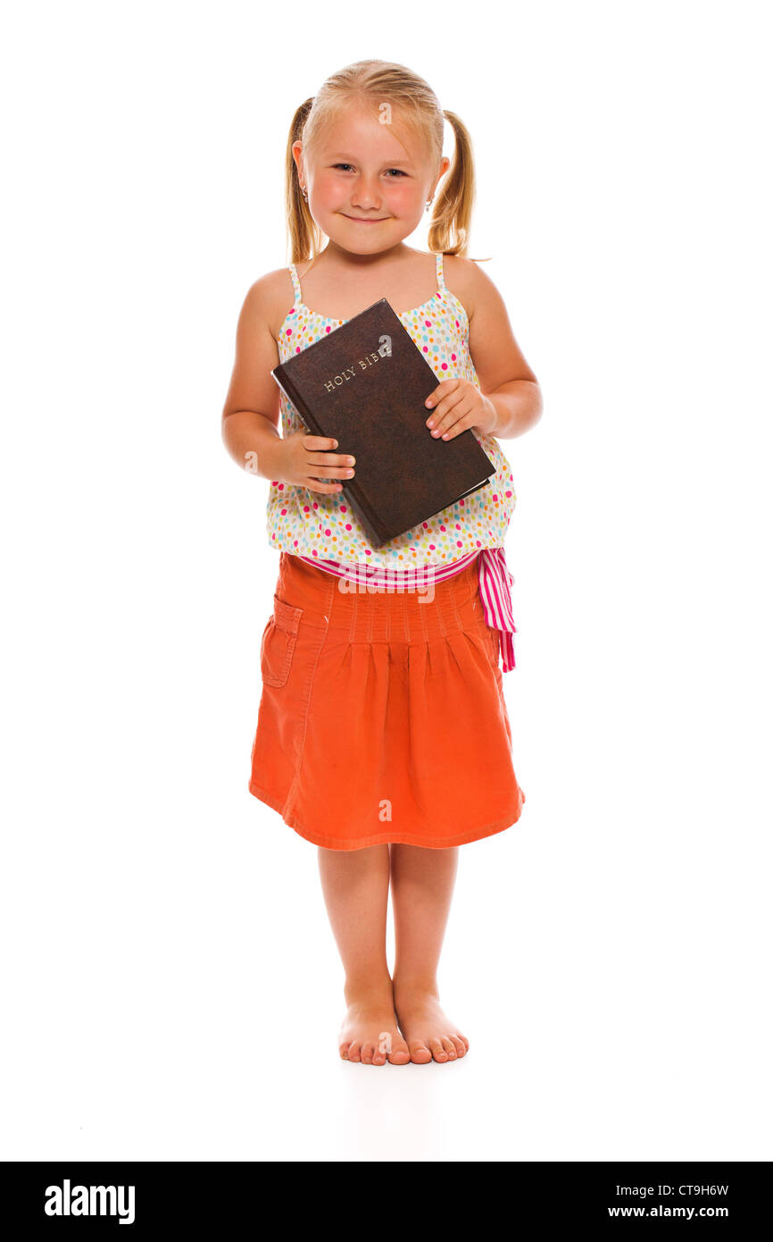 Das kleine Mädchen mit der Bibel. Studio auf weißem Hintergrund gedreht. Stockfoto