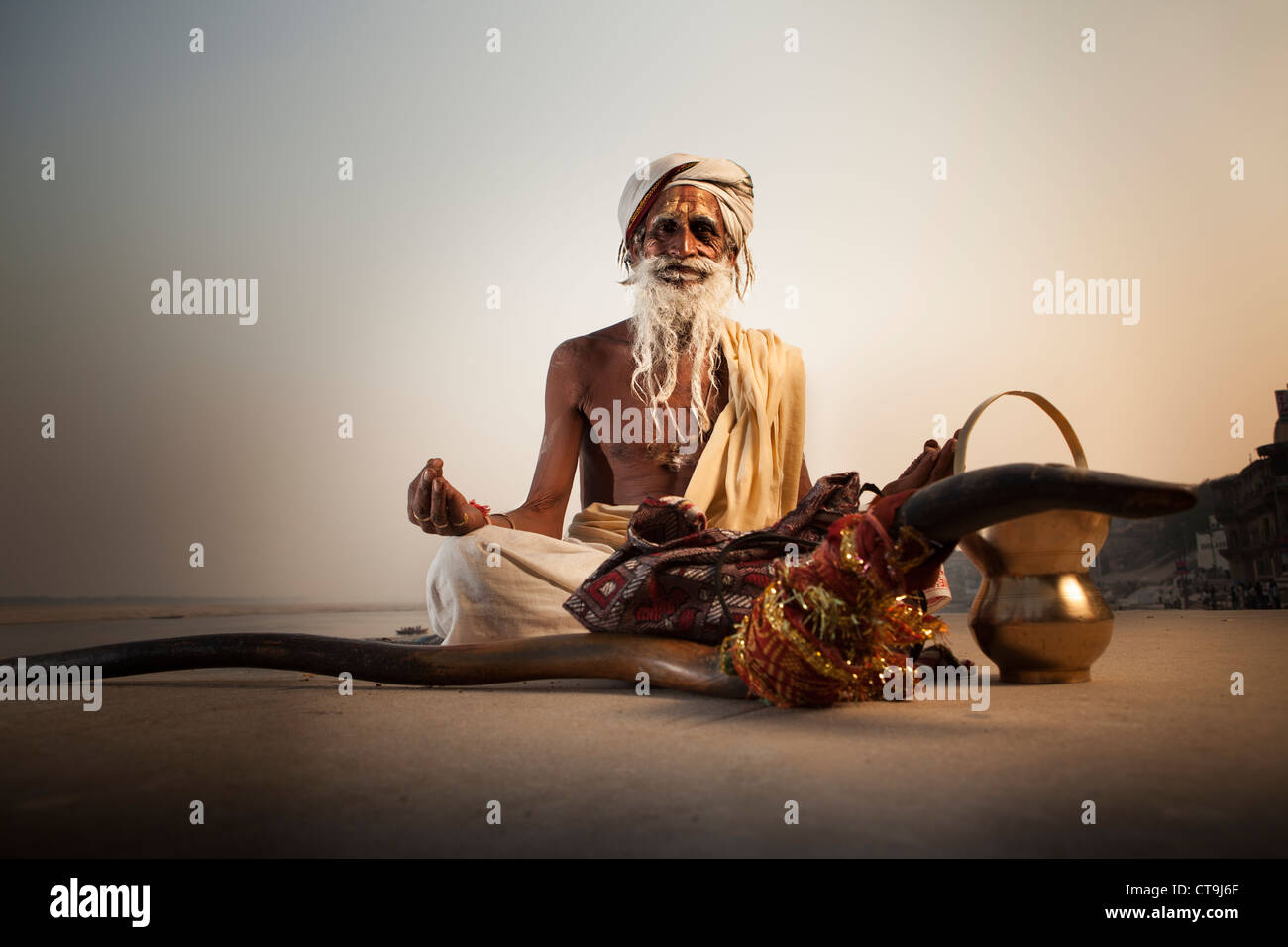 Hindu-Mönch Sadhu (als heiliger Mann) sitzen auf dem Ghat in Varanasi, Uttar Pradesh, Indien Stockfoto