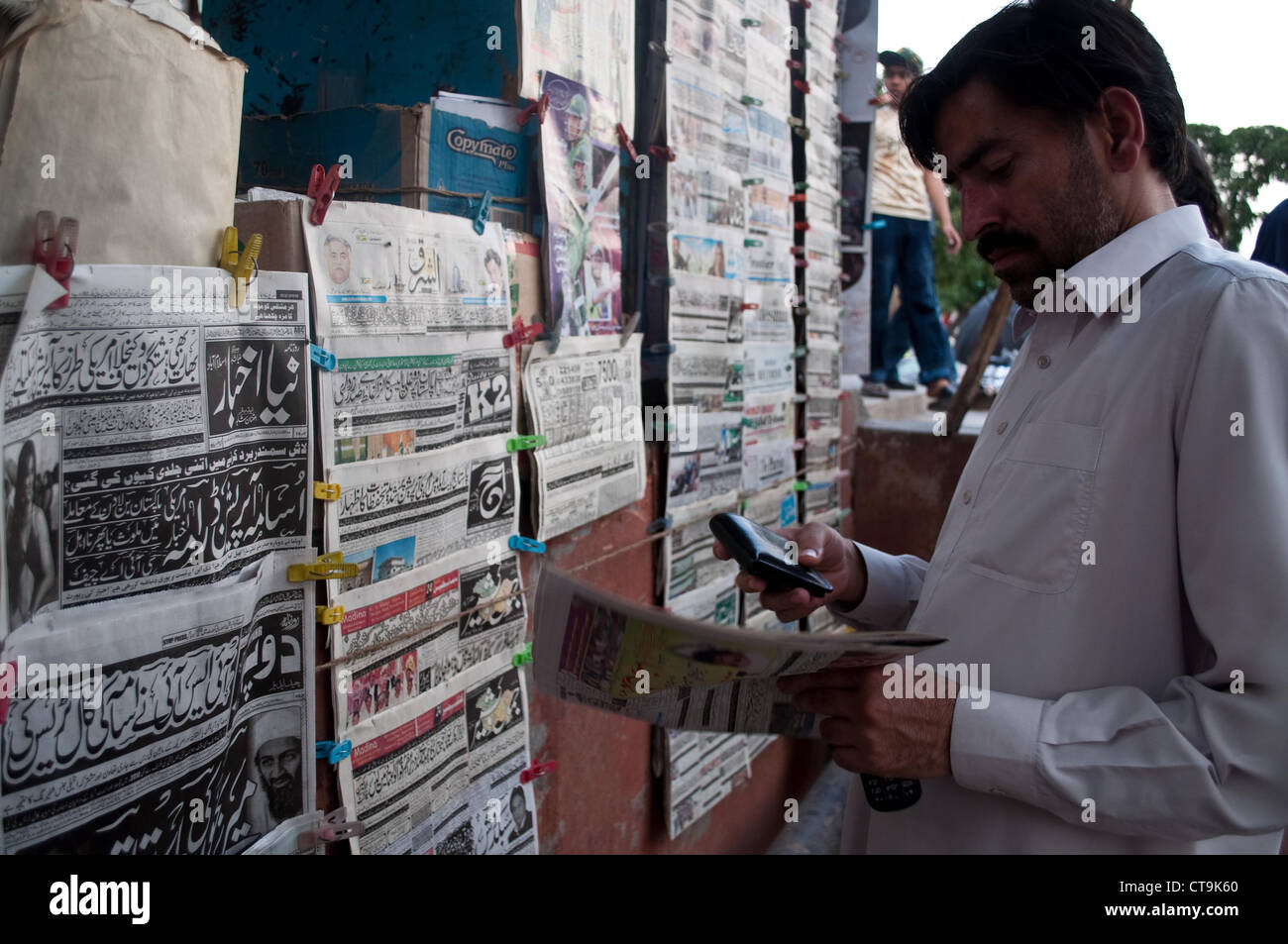 Pakistanischen Mann liest Zeitung, Islamabad Stockfoto