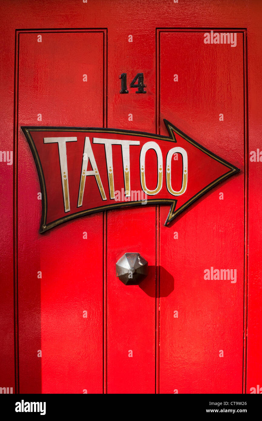 Tattoo-Pfeil auf rote Tür. Kinder lieben Tinte, Tattoo-Studio, Cheshire St. Bethnal Green. London Stockfoto