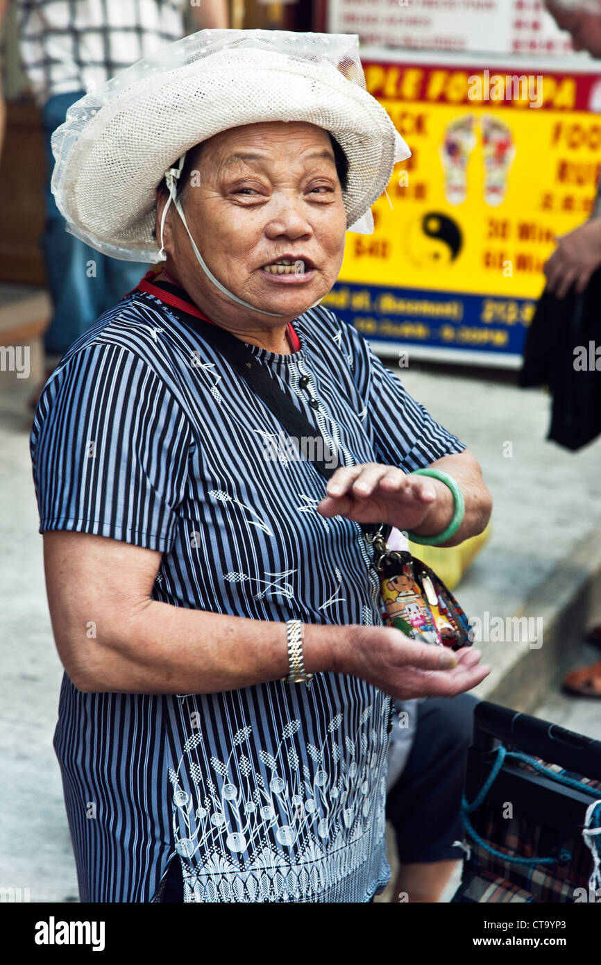 klassische faltige alte chinesische Dame Frau in herrlichen weißen Sonnenhut mit einem guten Klatsch auf Bürgersteig in Chinatown New York City Stockfoto