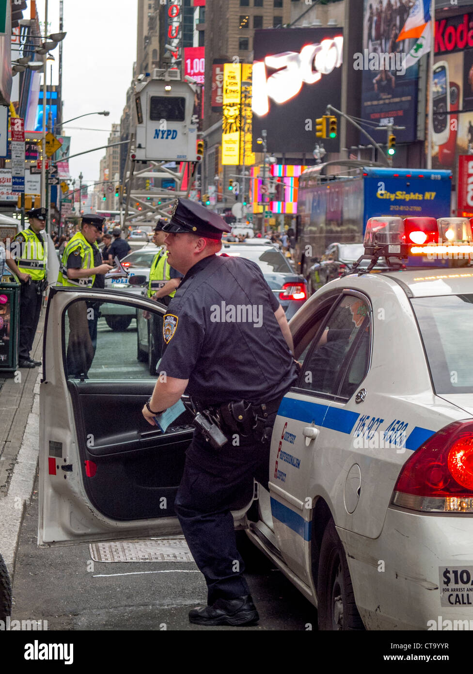 Entgegennehmen eines Anrufs, eilt ein Polizist aus seinem Streifenwagen in Times Square in New York City. Hinweis Polizei mobile Wachturm. Stockfoto