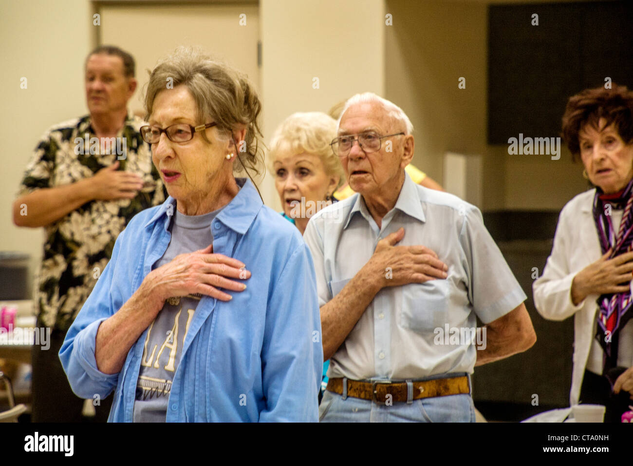 Senioren rezitieren die Pledge of Allegiance vor dem Mittagessen in einem Seniorenzentrum in Tustin, Kalifornien. Stockfoto