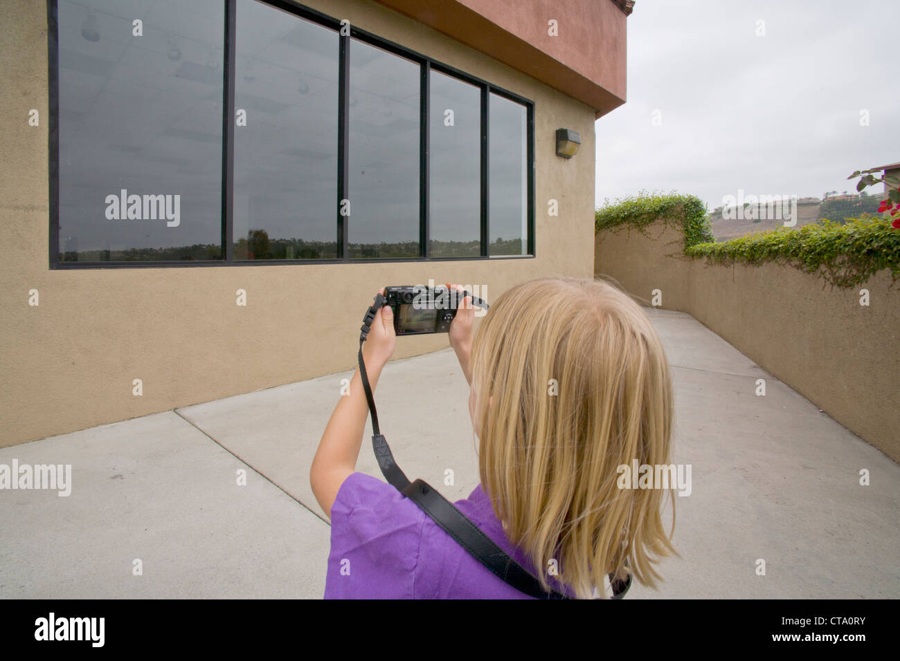 Sechs - Jahr-altes Mädchen nutzt einer Digitalkamera Fotografie die Fenster eines Einkaufszentrum Geschäftshauses in Mission Viejo, Kalifornien. Stockfoto