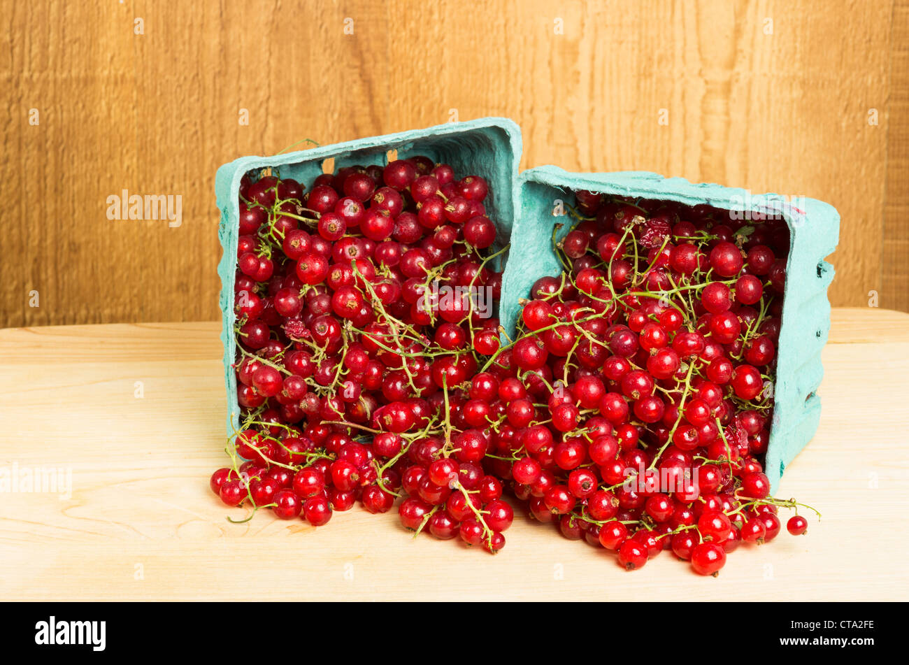 Kisten mit roten Johannisbeeren auf Holztisch Stockfoto