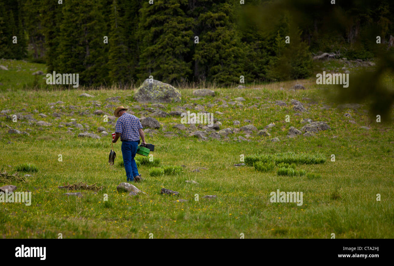 Fischer zu Fuß zurück ins Camp tragen einen Stringer von Fisch und Tackle Boxen. Stockfoto