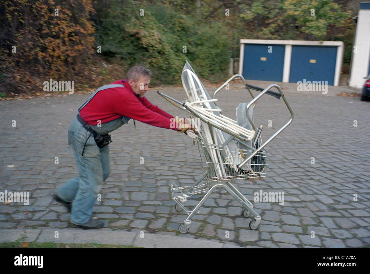 Arbeiter schiebt einen Wagen vor ihm, Berlin Stockfoto