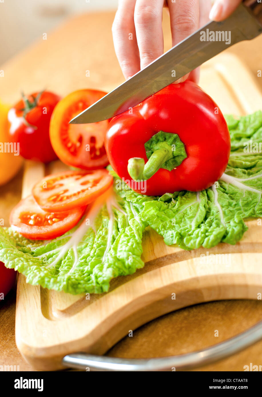 Frauenhand Tomaten Paprika, hinter frisches Gemüse schneiden. Stockfoto