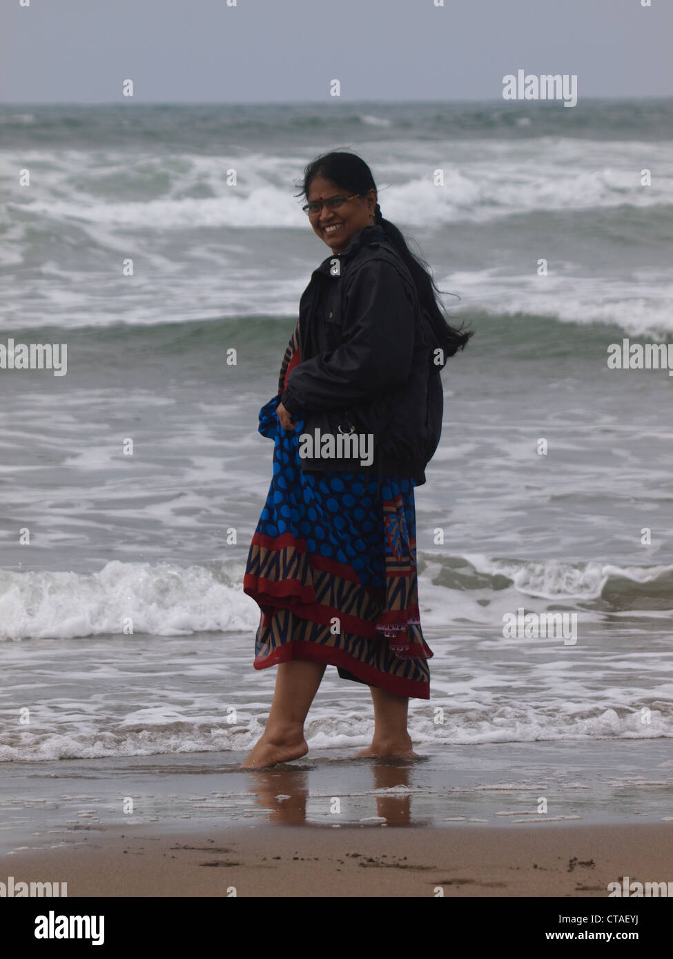 Asiatische Frau paddeln am Meer, Cornwall, UK Stockfoto